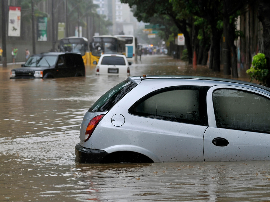 As Mudanças Climáticas_ Uma Ameaça à Vida na Terra: Imagem de uma enchente na cidade com alguns carros debaixo dagua
